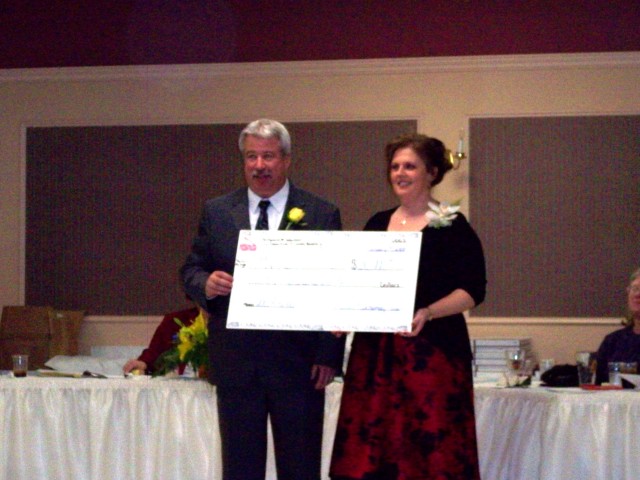 President John Montgomery accepting a check for $30,000 from the Ladies Auxiliary President, Karen Montgomery.
